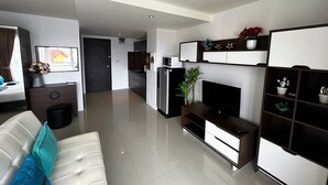 Un salon moderne avec un canapé, un téléviseur et un meuble de divertissement.