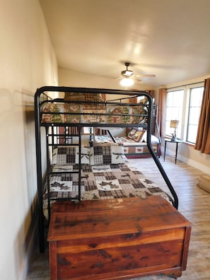Cozy retreat with a bunk bed, featuring a quilted mattress and a wooden headboard.