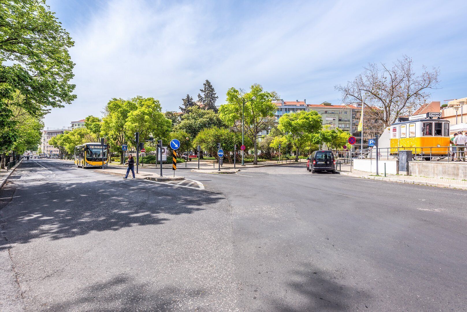 Un carrer amb un tramvia, arbres i edificis.