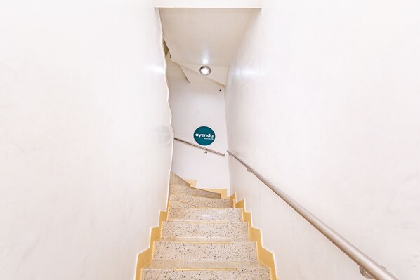 A narrow staircase with a handrail, leading to a door with a sign that reads "ayenda hotels". - Ayenda Golden Empresarial (Pereira)