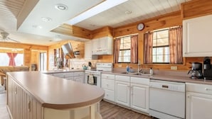 A spacious kitchen with wooden cabinets, a central island, and a built-in oven. - Sheep’s Knob Refuge- ..Take refuge in Him. Ps 34:8 (Franklin)