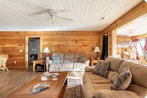 Relax in this inviting living room with a large sofa, wooden coffee table, and cozy side table.