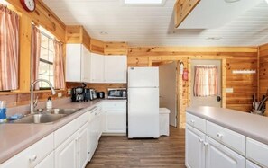 Kitchen with wooden cabinetry, stainless steel sink, and modern appliances.
