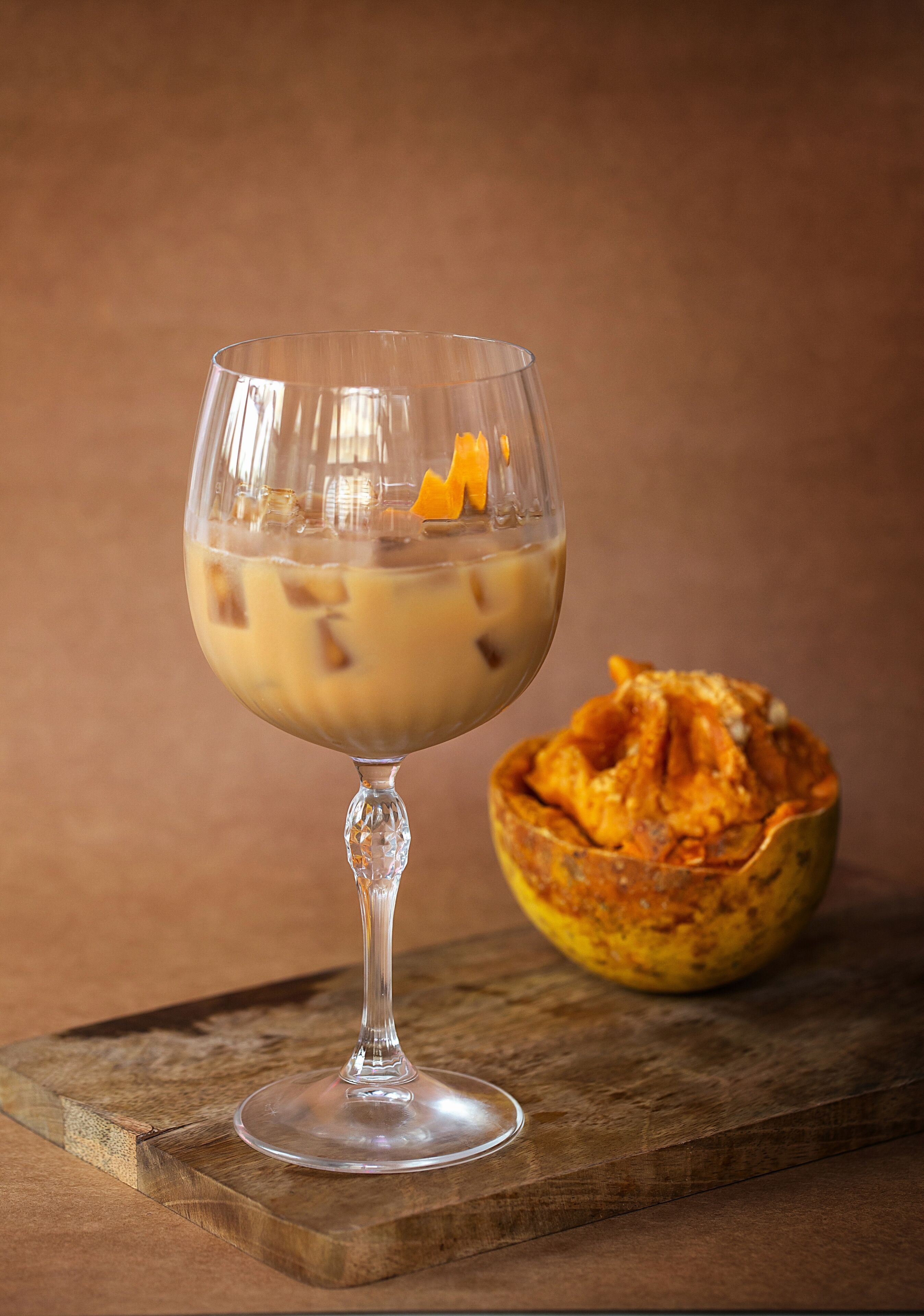A dessert in a glass on a wooden board.