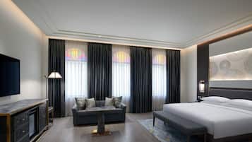 Una habitación de hotel moderna con una cama grande, un sofá, un televisor y un escritorio.