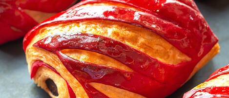 A close-up of glazed pastries with a shiny, red coating.