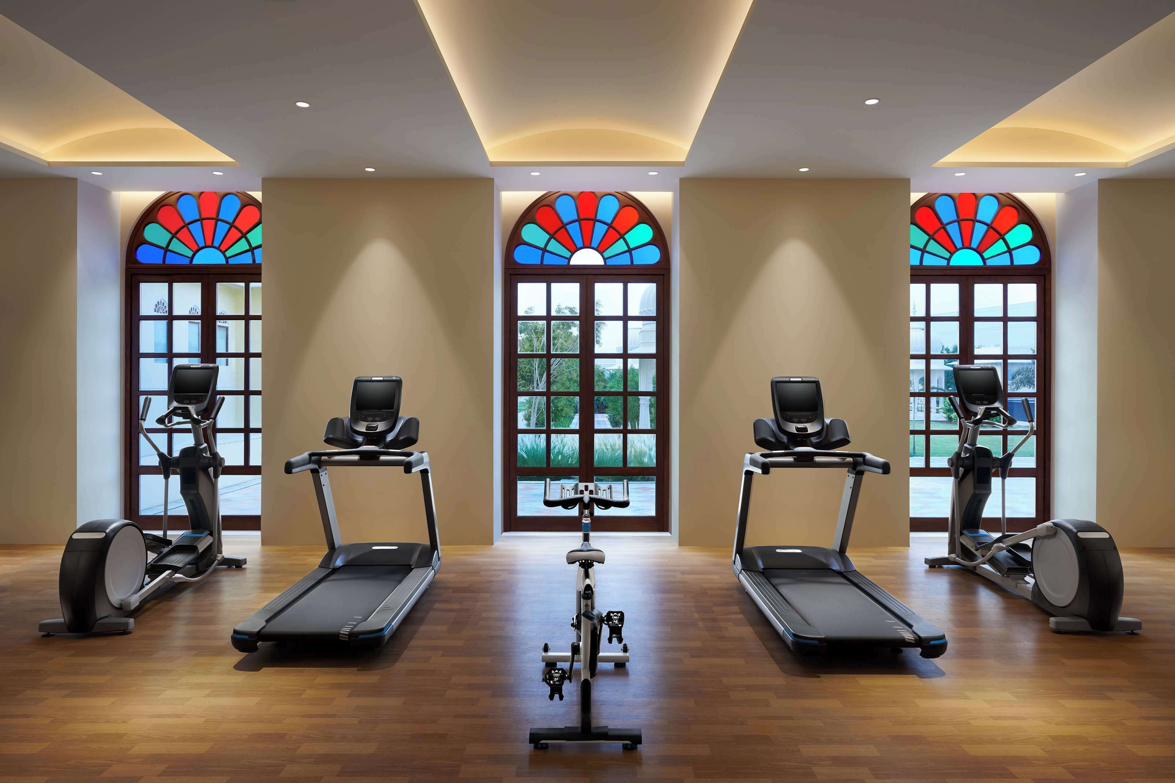 A gym with treadmills, elliptical machines, and a central bike.
