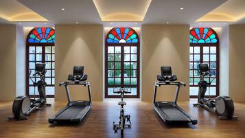 A gym with treadmills, elliptical machines, and a central bike.