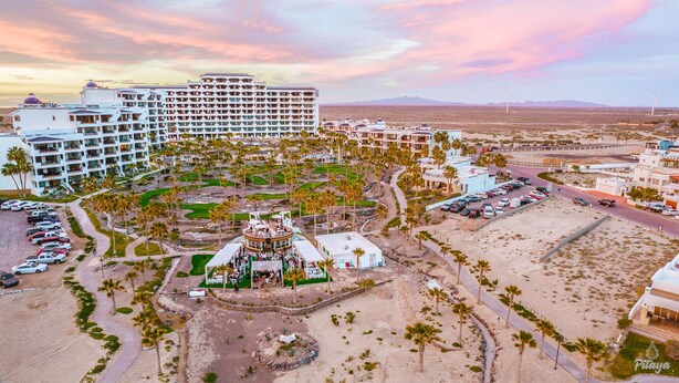 A resort with multiple buildings, a central pool area, and a desert landscape.