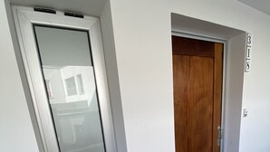 A hallway with a white door, a wooden door, and a number sign '3/8' on the wall. - Donna Alda Tower incredible views (Salta)