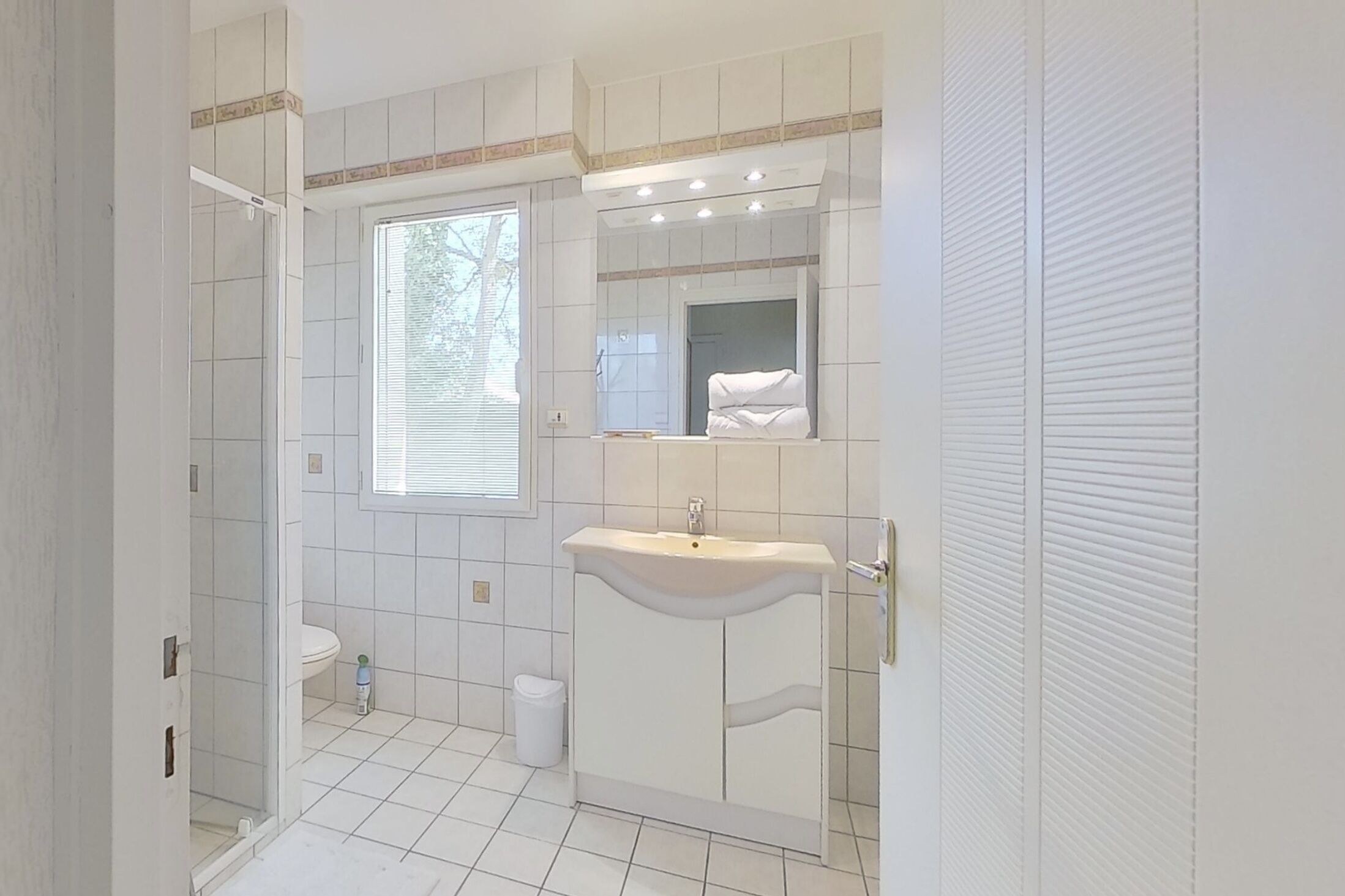 A bathroom with a toilet, sink, and shower area.