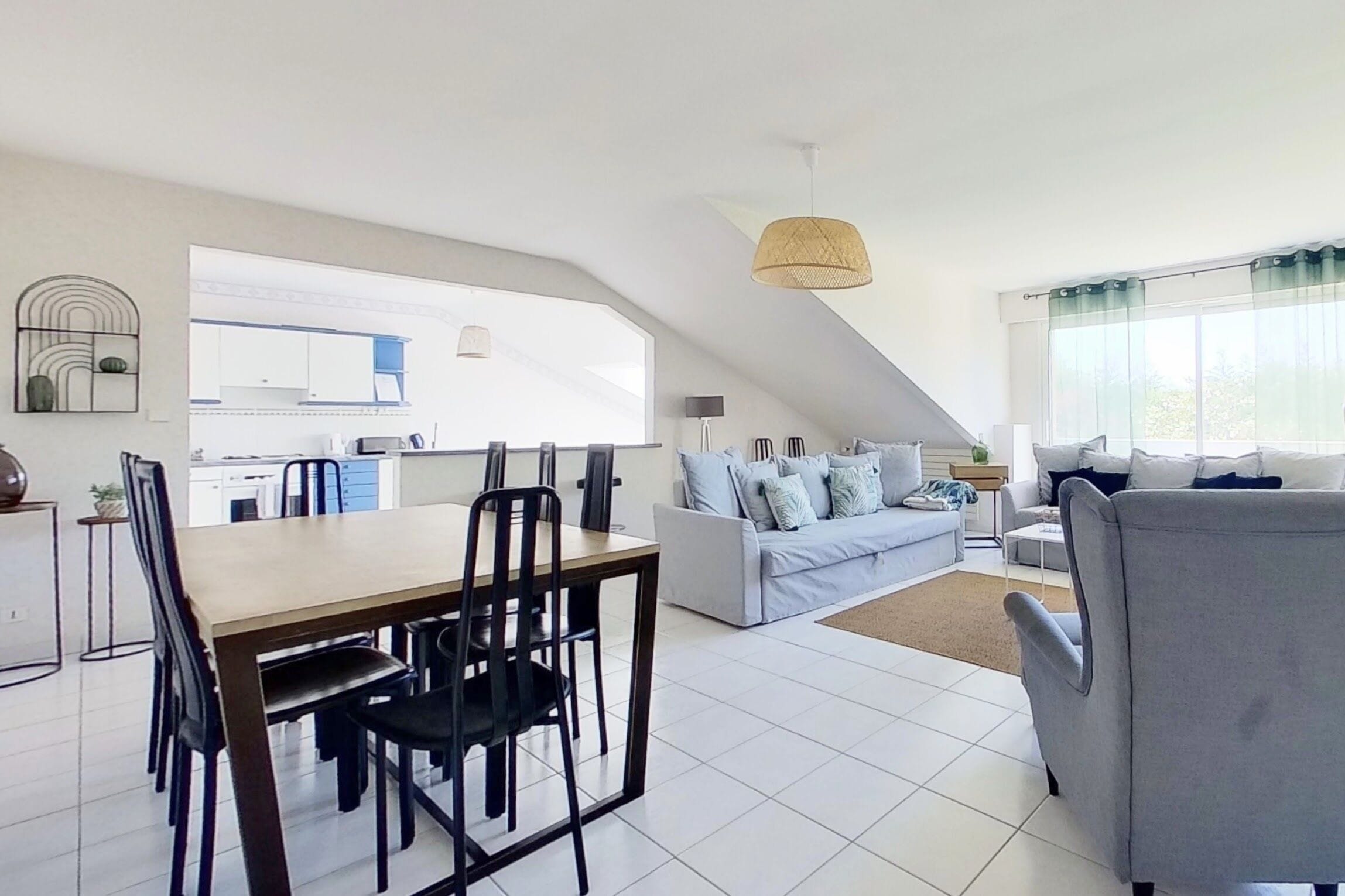 A modern loft apartment with a dining area, kitchen, and living space.
