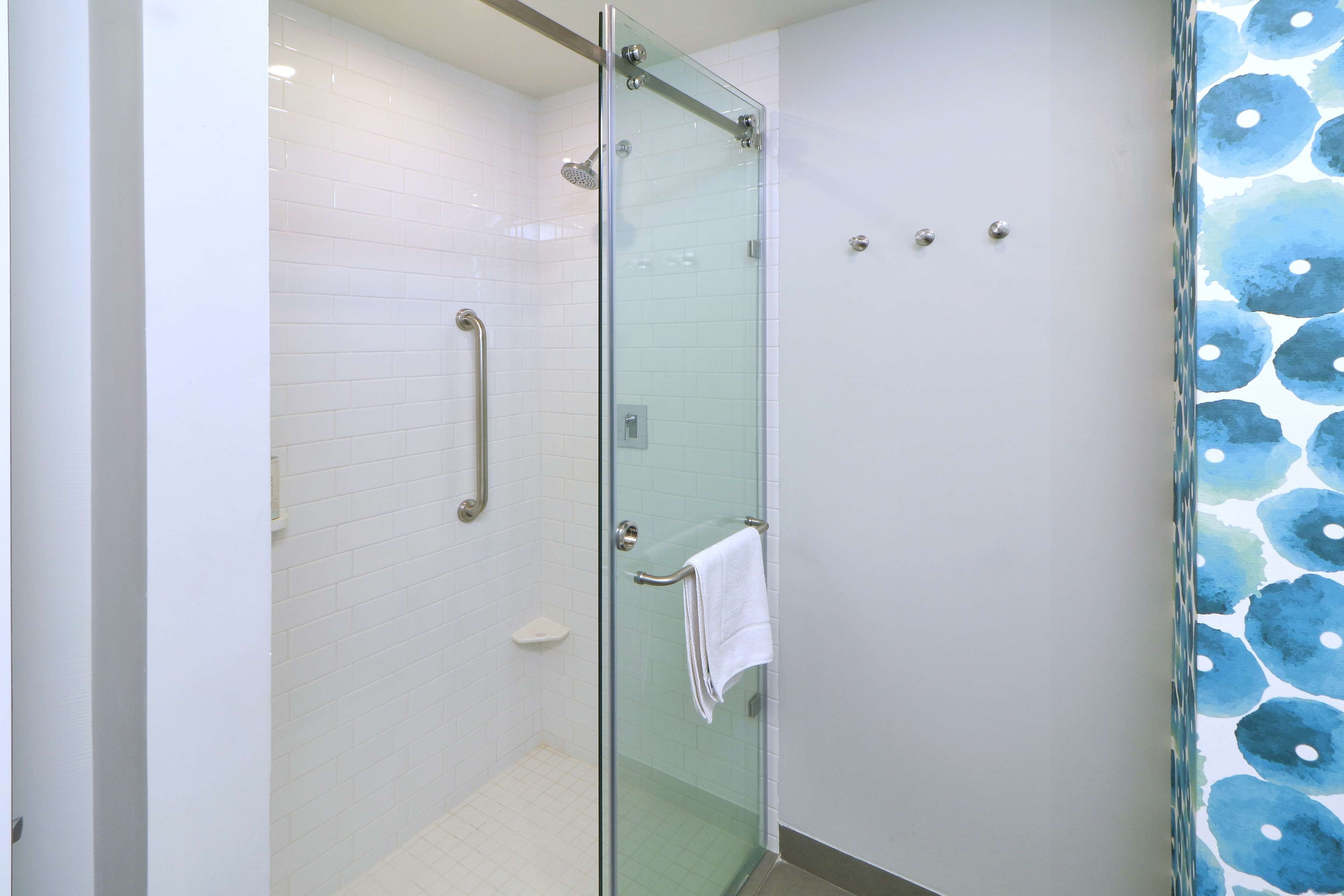 A glass-enclosed shower with a white towel hanging on the door handle.