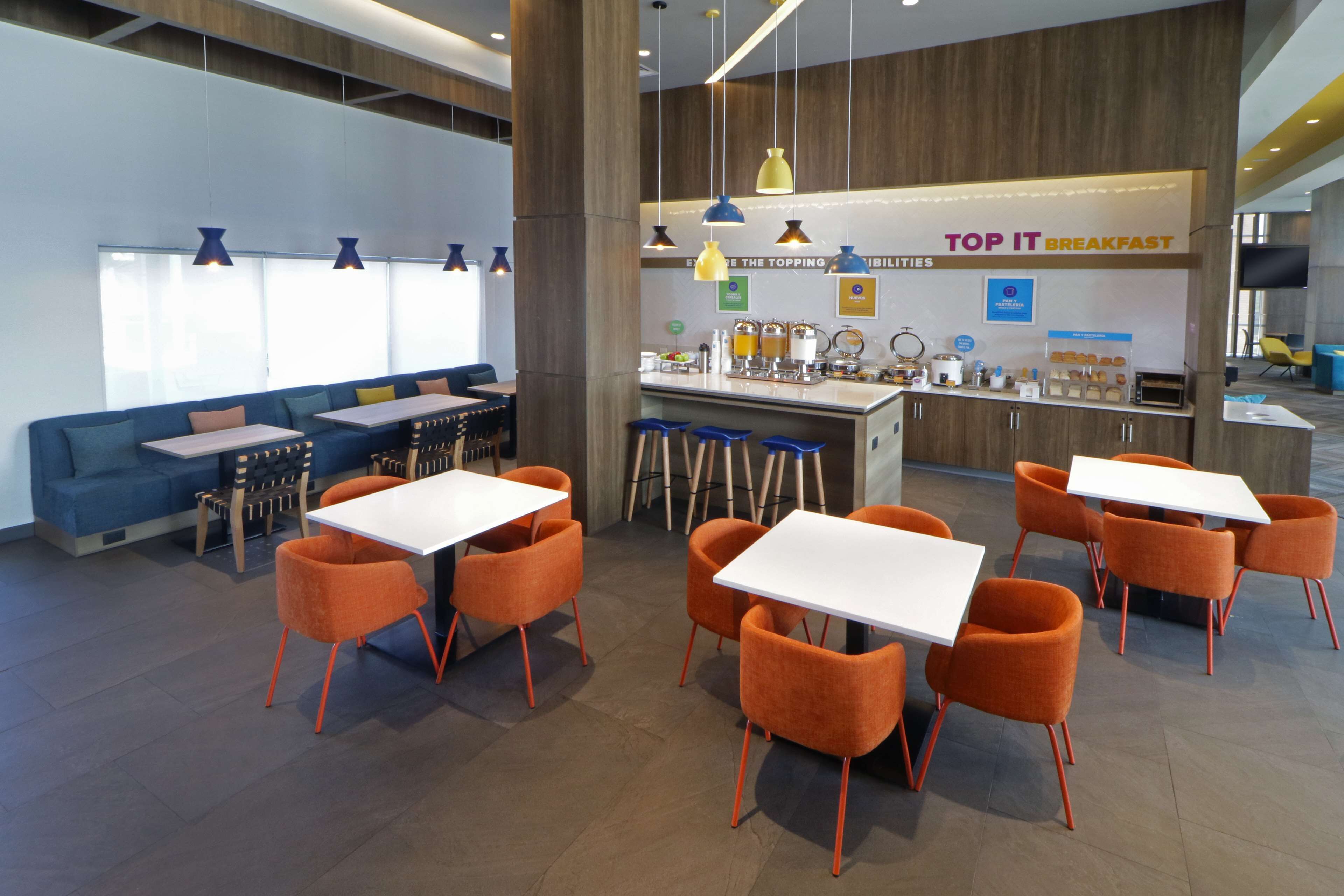 Un espace moderne dédié au petit-déjeuner, avec un comptoir, des sièges et un canapé bleu.