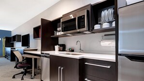 A modern kitchen with stainless steel appliances, a built-in microwave, and a coffee maker. - Home2 Suites By Hilton Redding (Redding)