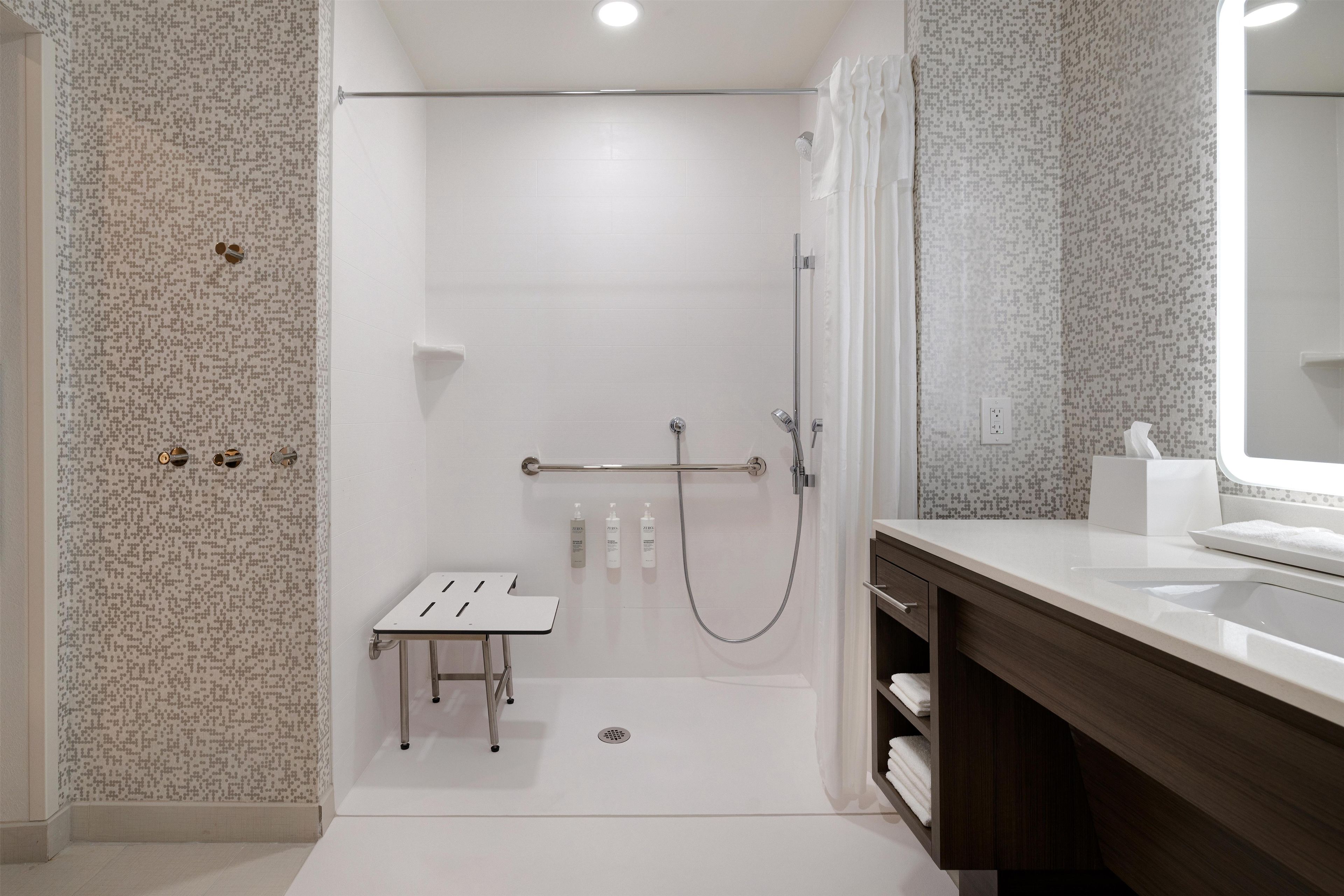A modern bathroom with a shower, a vanity, and a toilet.