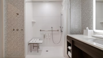 A modern bathroom with a shower, a vanity, and a toilet.