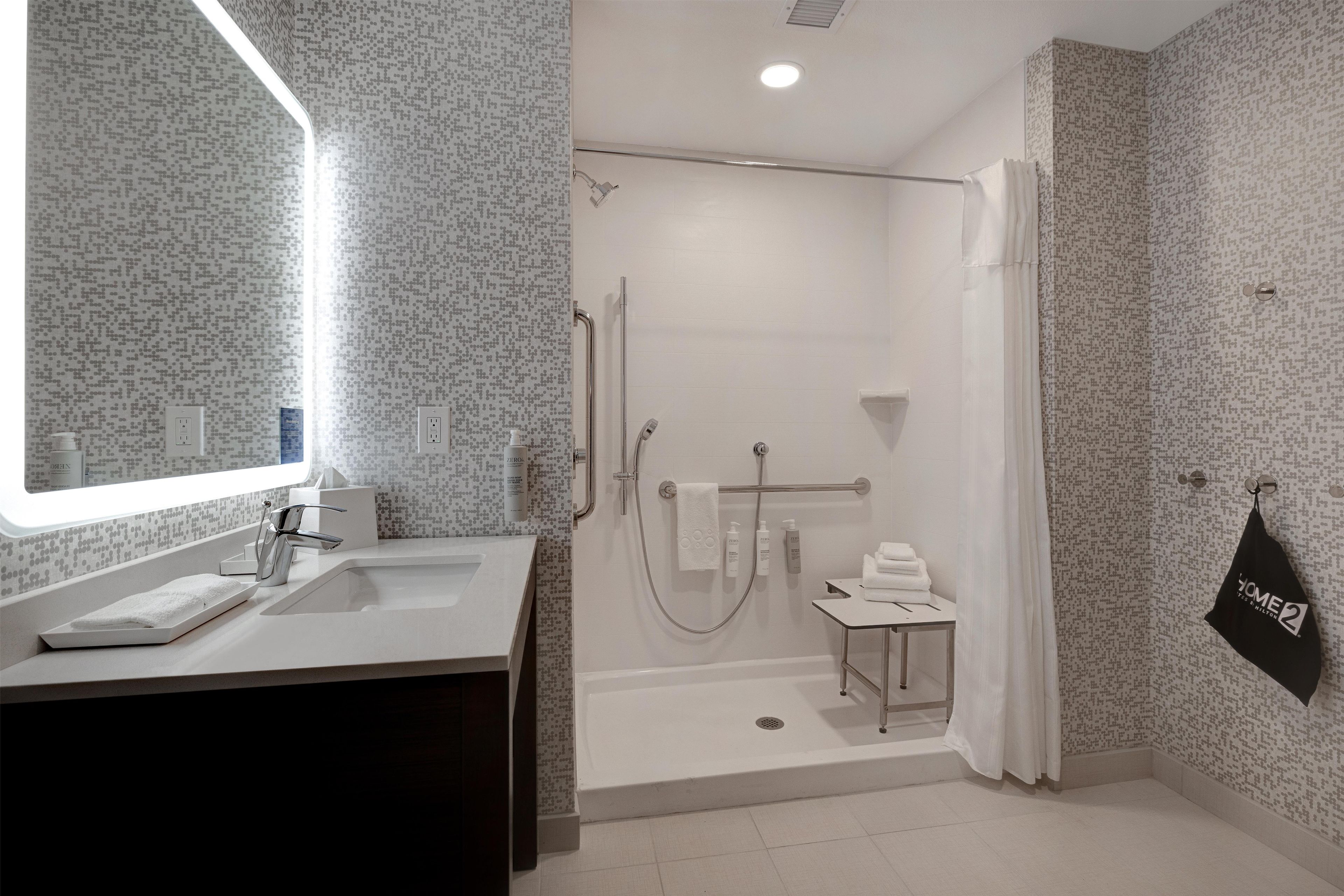 A modern bathroom with a shower, a sink, and a vanity.