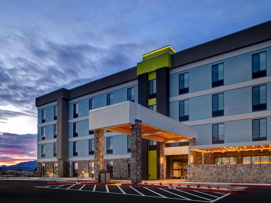 A multi-story hotel with a covered entrance and stone pillars.