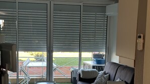 A modern living room with a grey sofa, a small table, and a kitchen area.