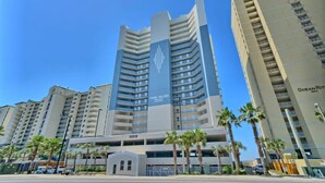 A high-rise hotel with a prominent 'TWIN PALMS' sign, multiple balconies, and a parking garage.