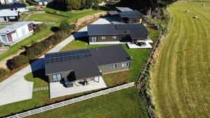 Una zona residencial con casas modernas, paneles solares y un césped bien cuidado.