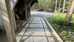 Un sendero de piedra que conduce a un área cubierta con una estructura de madera rústica.