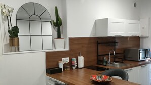 Eine moderne Küche mit Holzarbeitsplatte, Barhocker, Spüle und Mikrowelle.