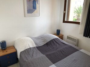 2 dormitorios y tabla de planchar con plancha