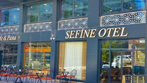 Fachada de un hotel con un cartel grande que dice "SEFINE OTEL".