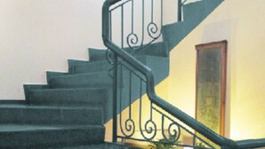 A staircase with black railings and a yellow wall. - Hotel La Muralla (Toluca)