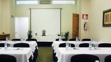 A conference room with tables set for a meeting, equipped with water bottles and nameplates.
