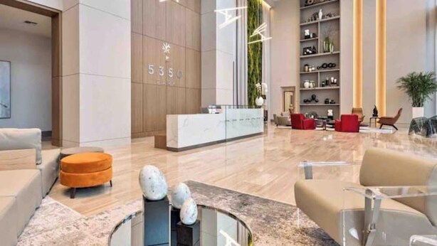 A modern lobby with a reception desk, seating area, and a large vertical garden. - Luxury apartment in Doral miami, 1 Bd (Doral)