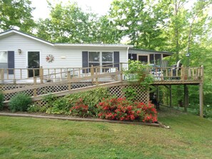 A white house with a wooden deck and a covered porch. - Beautiful cabin overlooking Crooked Creek on the Tennessee river (Lobelville)