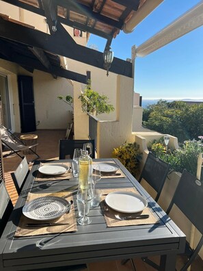 Enjoy a romantic meal under the shade of a pergola with a serene view of the surrounding landscape.