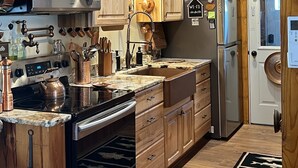 Una cucina con mobili in legno, un forno a microonde in acciaio inossidabile, un bollitore ed un frigorifero.