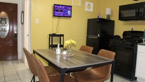 A dining area with a wooden table and brown chairs, a black refrigerator, a stove, and a microwave. - Cozy Villa 10 minutes walk to riverwalk, Hemispher park and convenstion center. (San Antonio)
