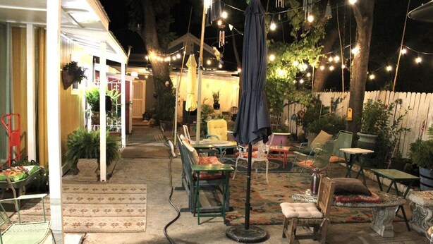 An outdoor patio area with tables and chairs, string lights, and umbrellas. - Cozy Villa 10 minutes walk to riverwalk, Hemispher park and convenstion center. (San Antonio)