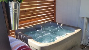 A hot tub with steps leading up to it, a wooden fence, and a potted plant. - Lodging and entertainment all wrapped into one great place! (Apache Junction)