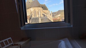 Una habitación con ventana que da a un edificio histórico con cúpula y torres.