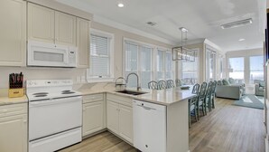 A modern kitchen with white cabinetry, a built-in microwave, and a dishwasher.