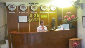 A hotel reception desk with clocks displaying times for Paris, London, Hanoi, Moscow, and New York. - A25 Hotel New Asean (Hanoi)