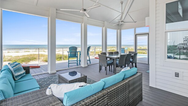 A covered outdoor area with a view of the beach, furnished with a sofa, chairs, and a dining table. - Luxury Gulf-Front Retreat. Heated Pool, Pet-Friendly.  (Cape San Blas)