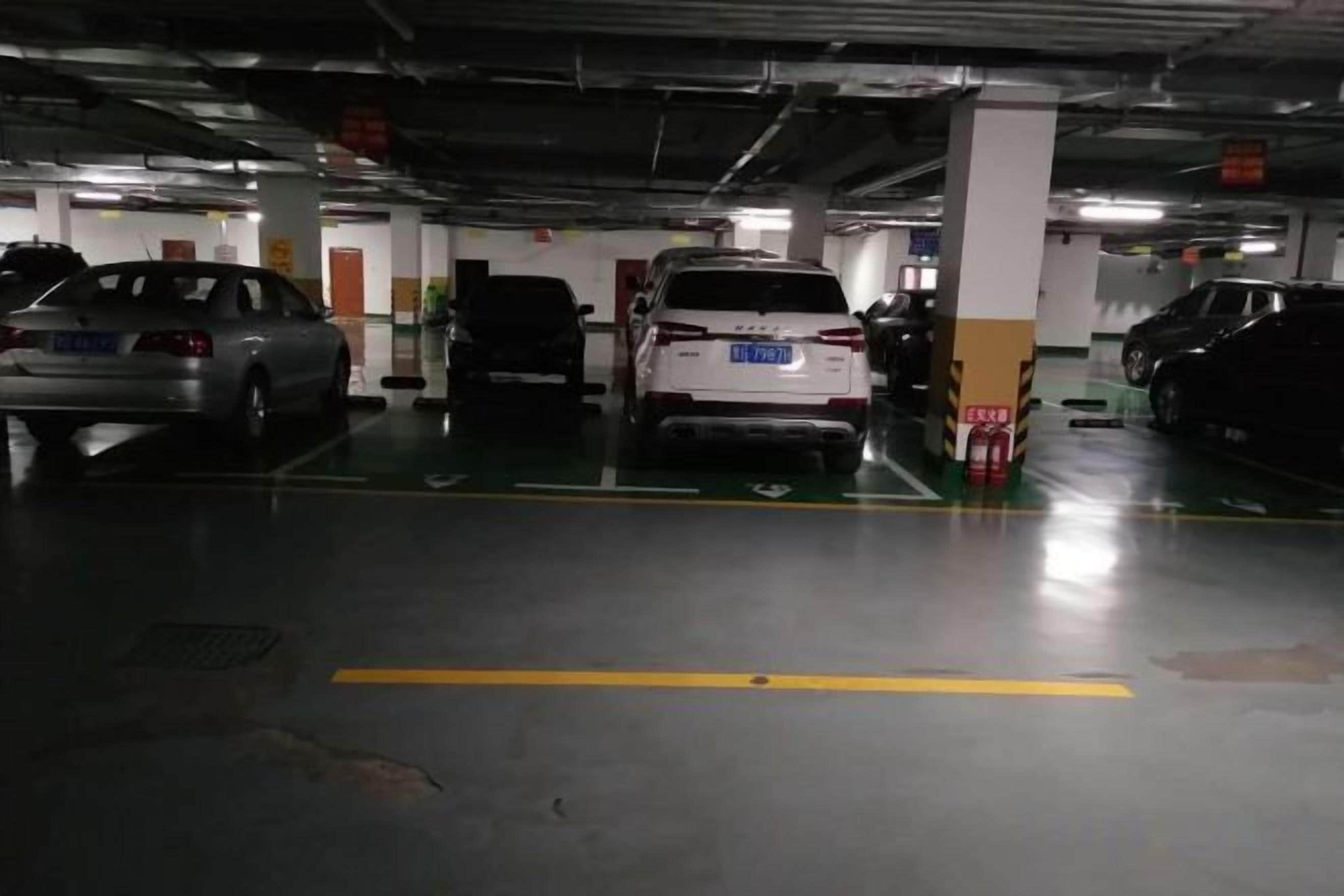 Un parking à plusieurs niveaux où sont stationnées plusieurs voitures.