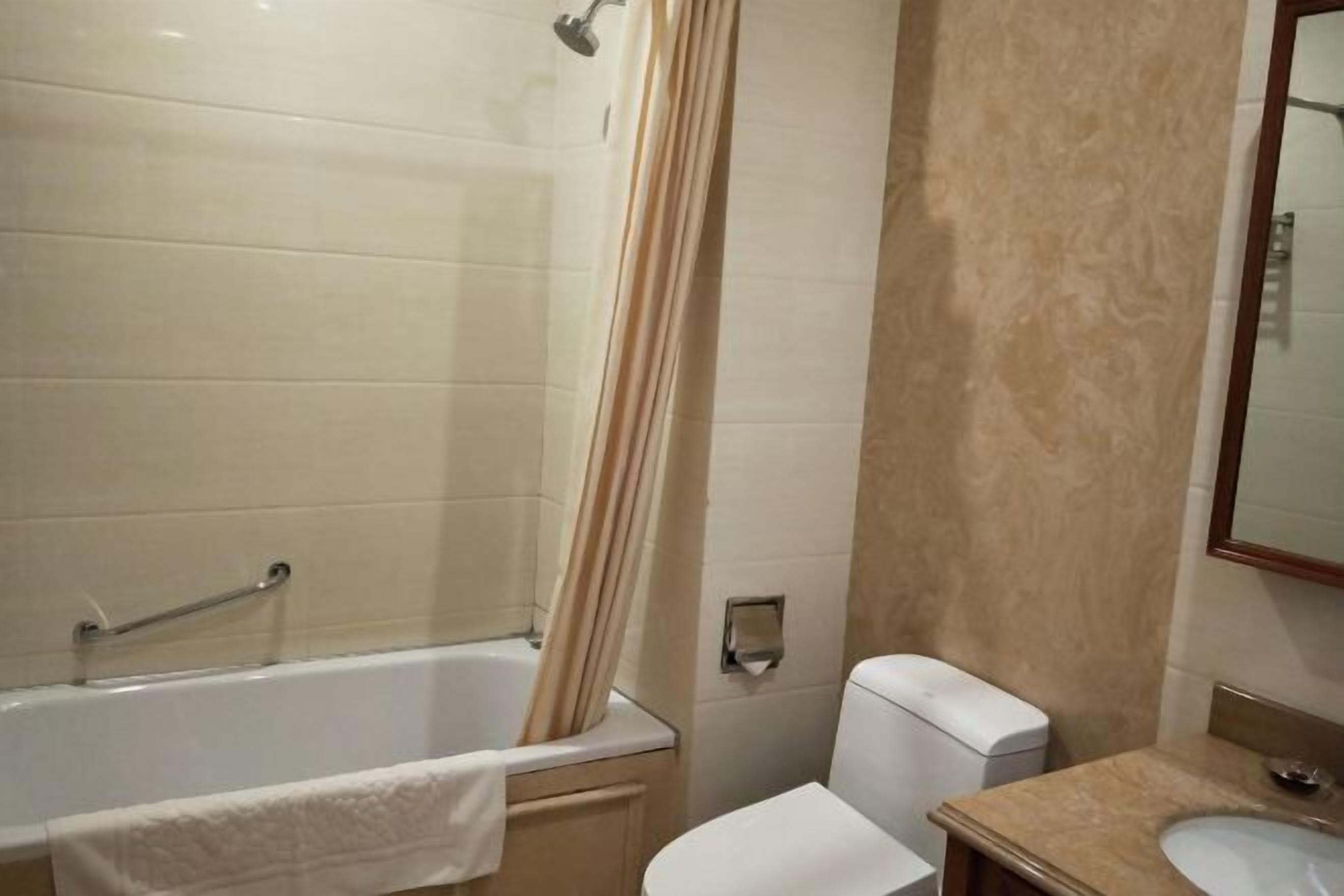 A bathroom with a bathtub, toilet, and sink.