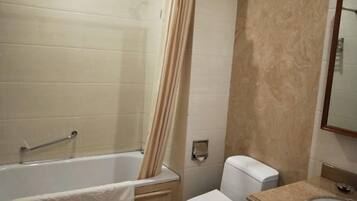 A bathroom with a bathtub, toilet, and sink.
