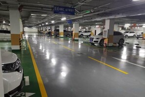 A multi-level parking garage with cars parked on different levels, clear signage, and a clean, well-maintained floor. - Xishihui Hotel (Mishan)