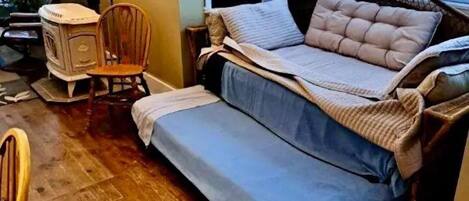 Una camera da letto compatta con un letto, una sedia e un piccolo tavolo.