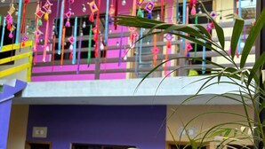 Un immeuble à plusieurs étages doté de balcons décorés d’ornements colorés suspendus.