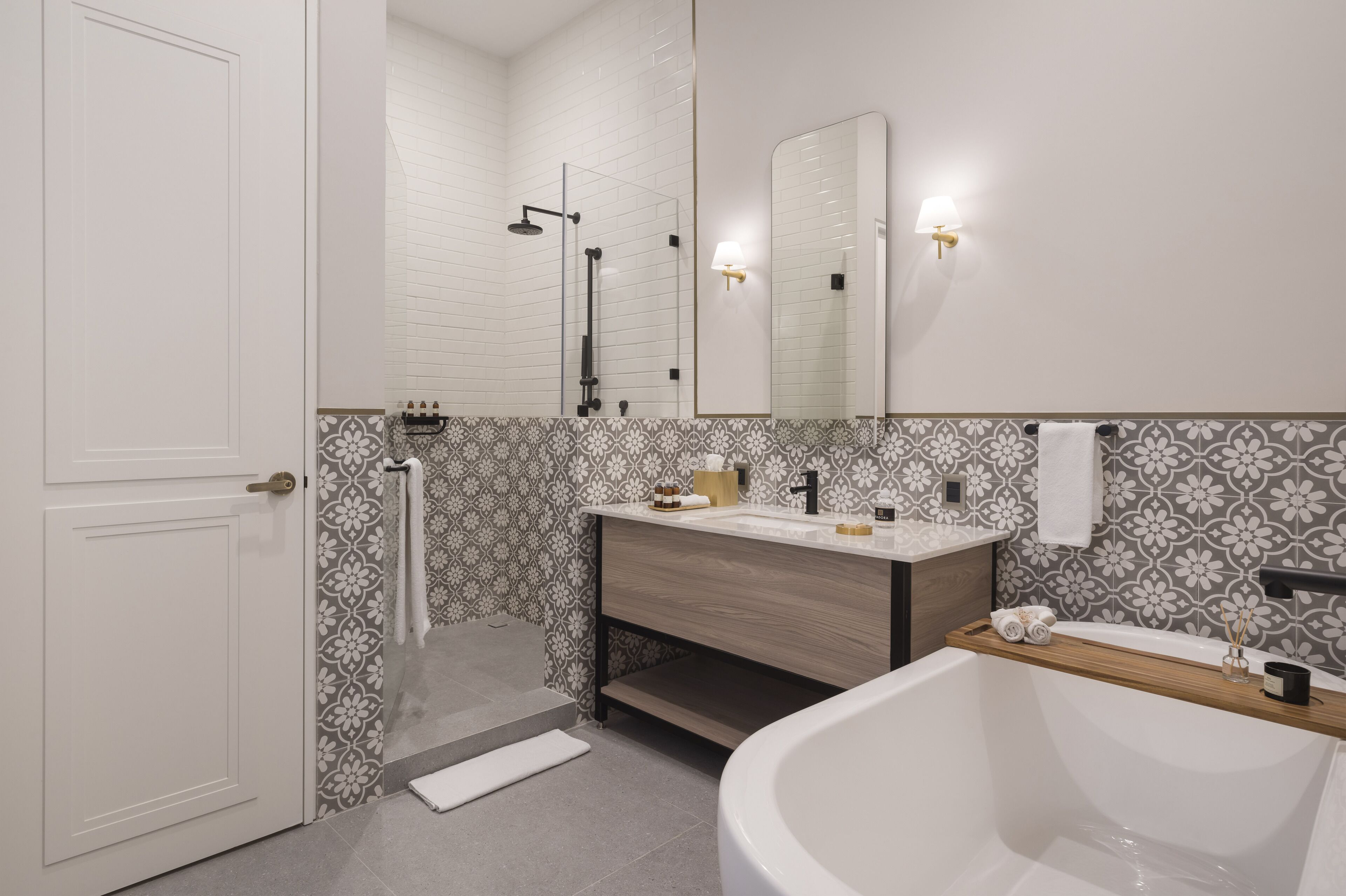 Un baño moderno con una bañera blanca, un tocador de madera, un espejo grande y cabina de ducha.